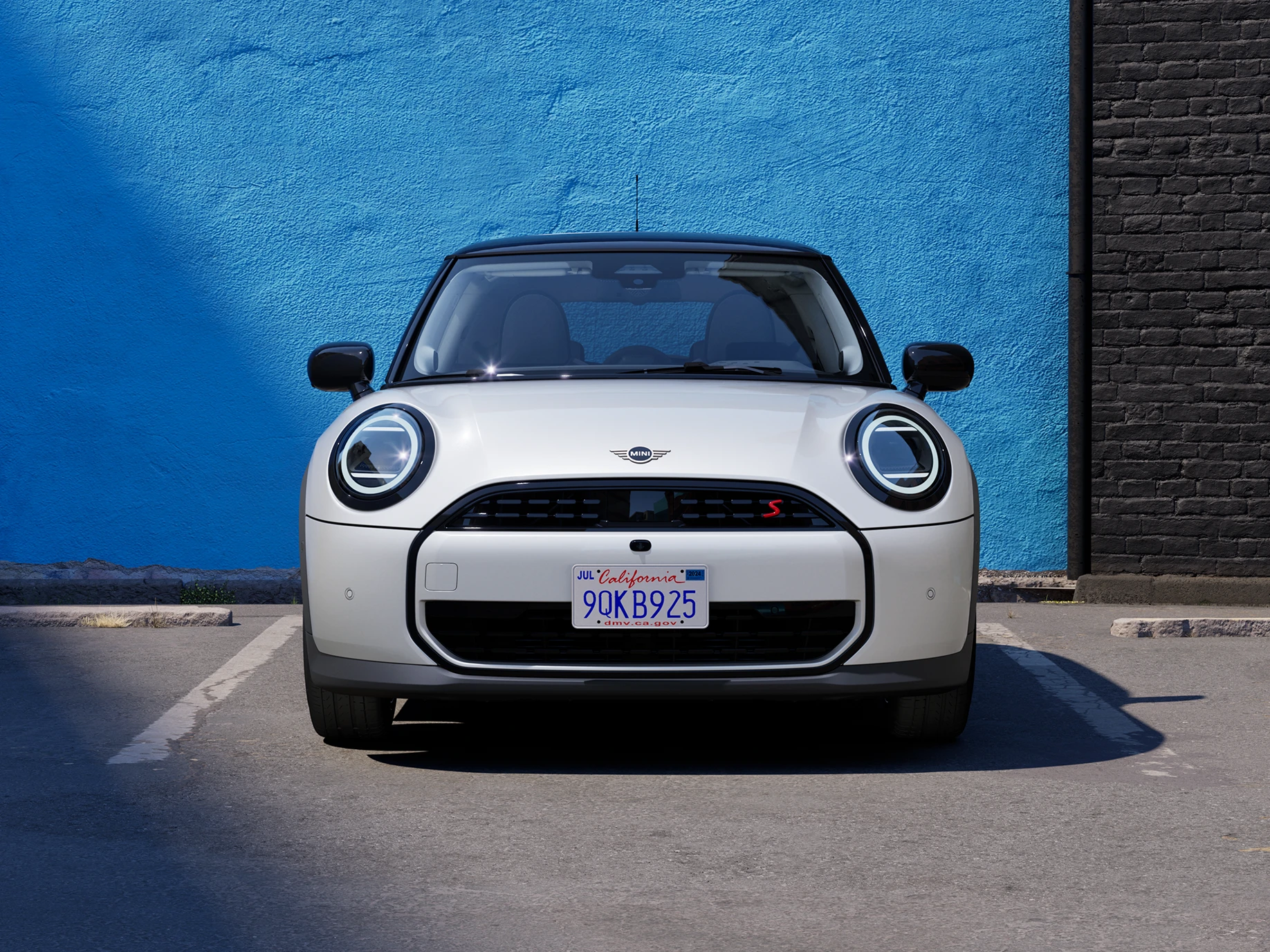 Vista frontal de um MINI Cooper estacionado em Nanuq White com tejadilho preto.