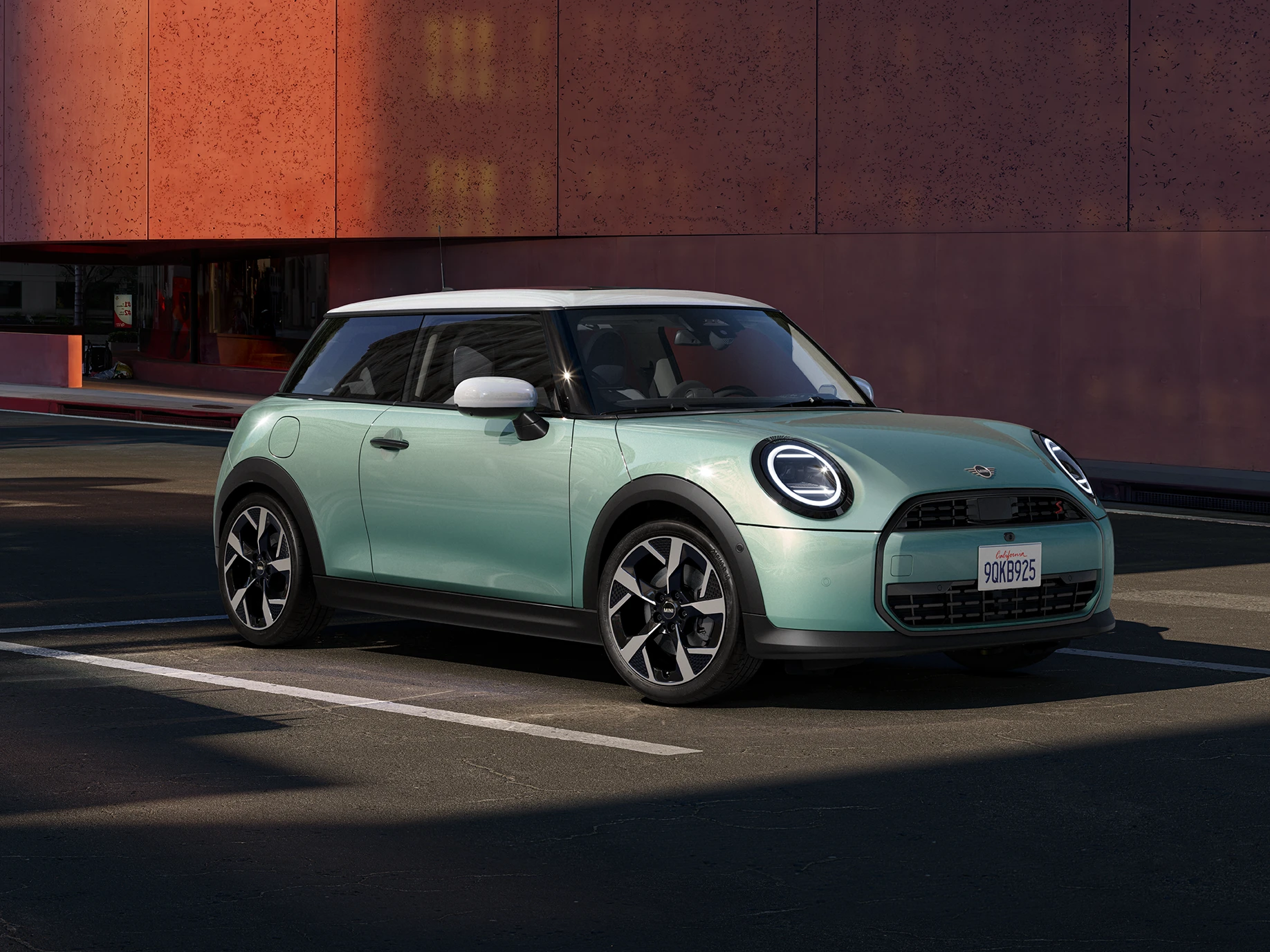 Vista frontal lateral do MINI Cooper em Ocean Wave Green e tejadilho branco.