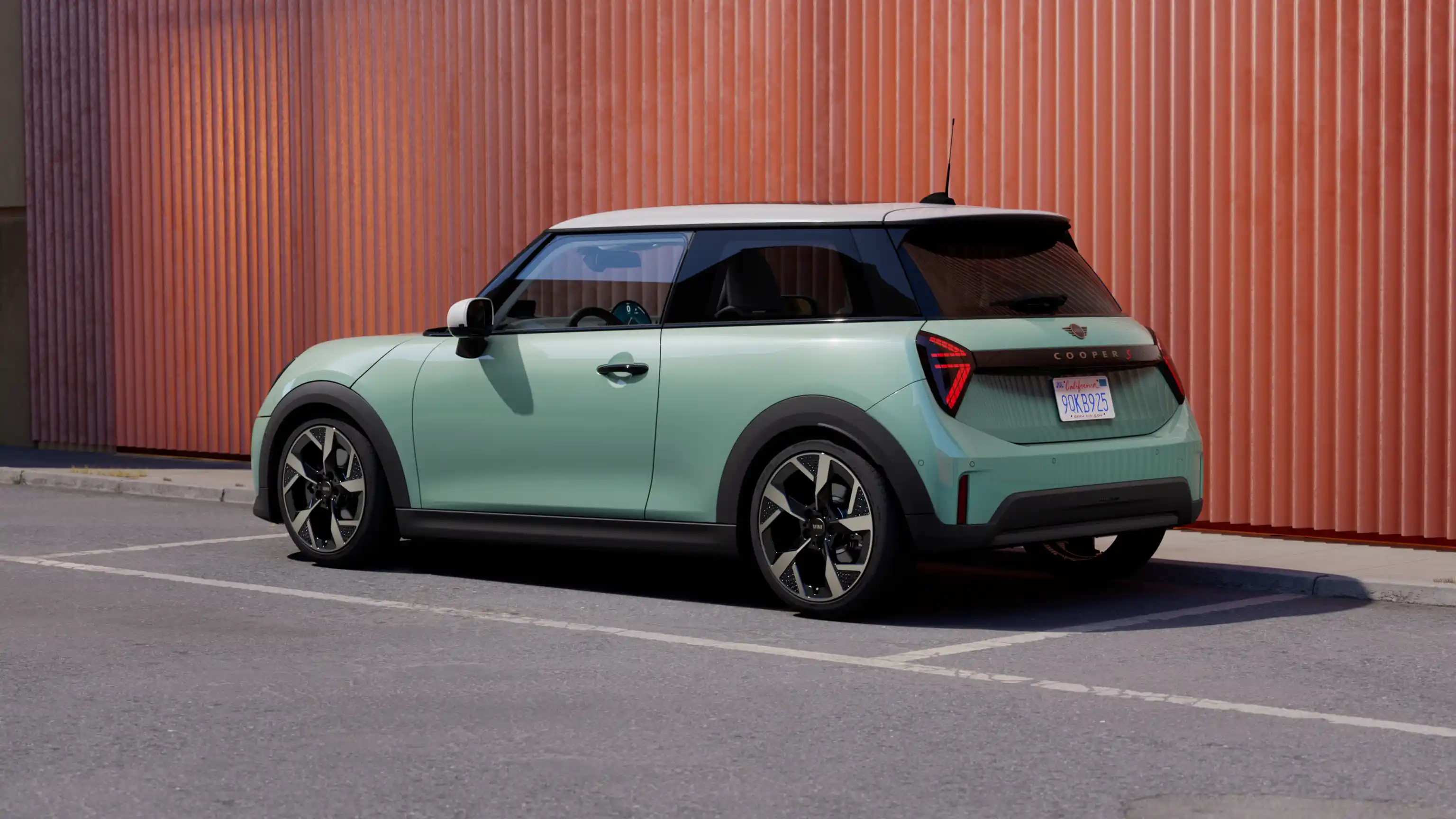 Vista traseira esquerda de um MINI Cooper em Ocean Wave Green com White Roof estacionado