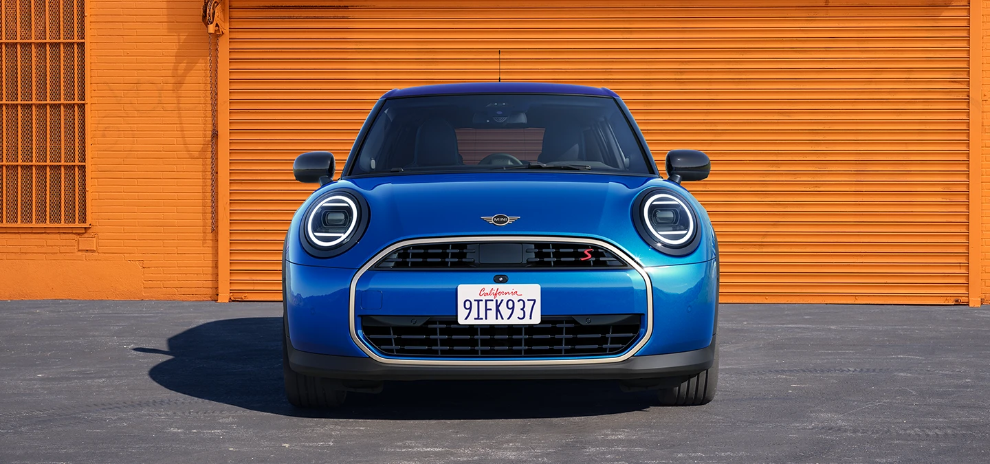 Vista frontal do MINI Cooper de 5 portas em Icy Sunshine Blue e tejadilho Multitone em azul.