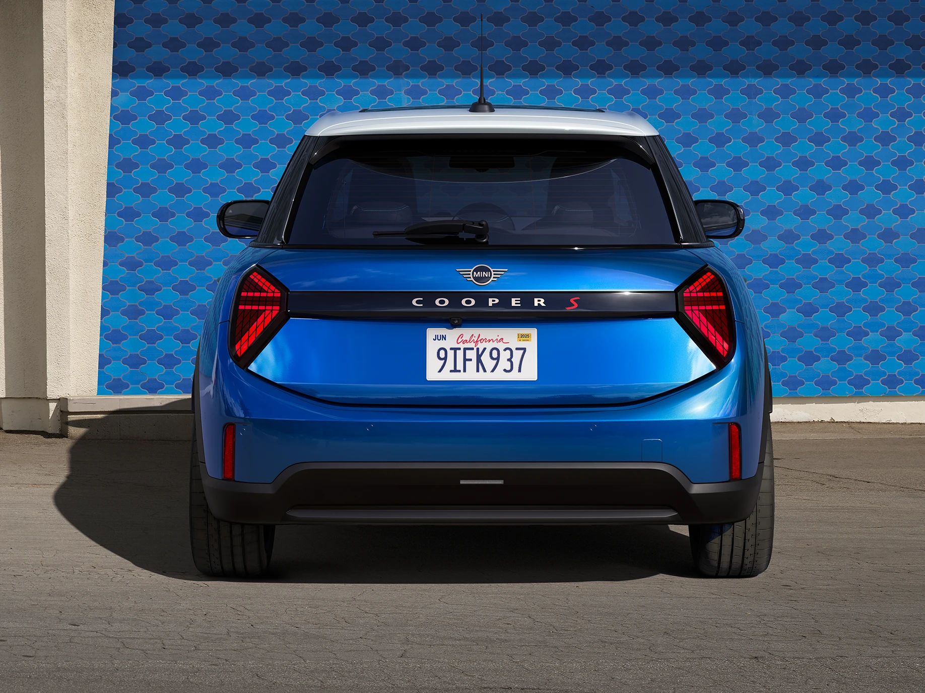 Vista traseira do MINI Cooper de 5 portas em Icy Sunshine Blue e tejadilho Multitone em azul.