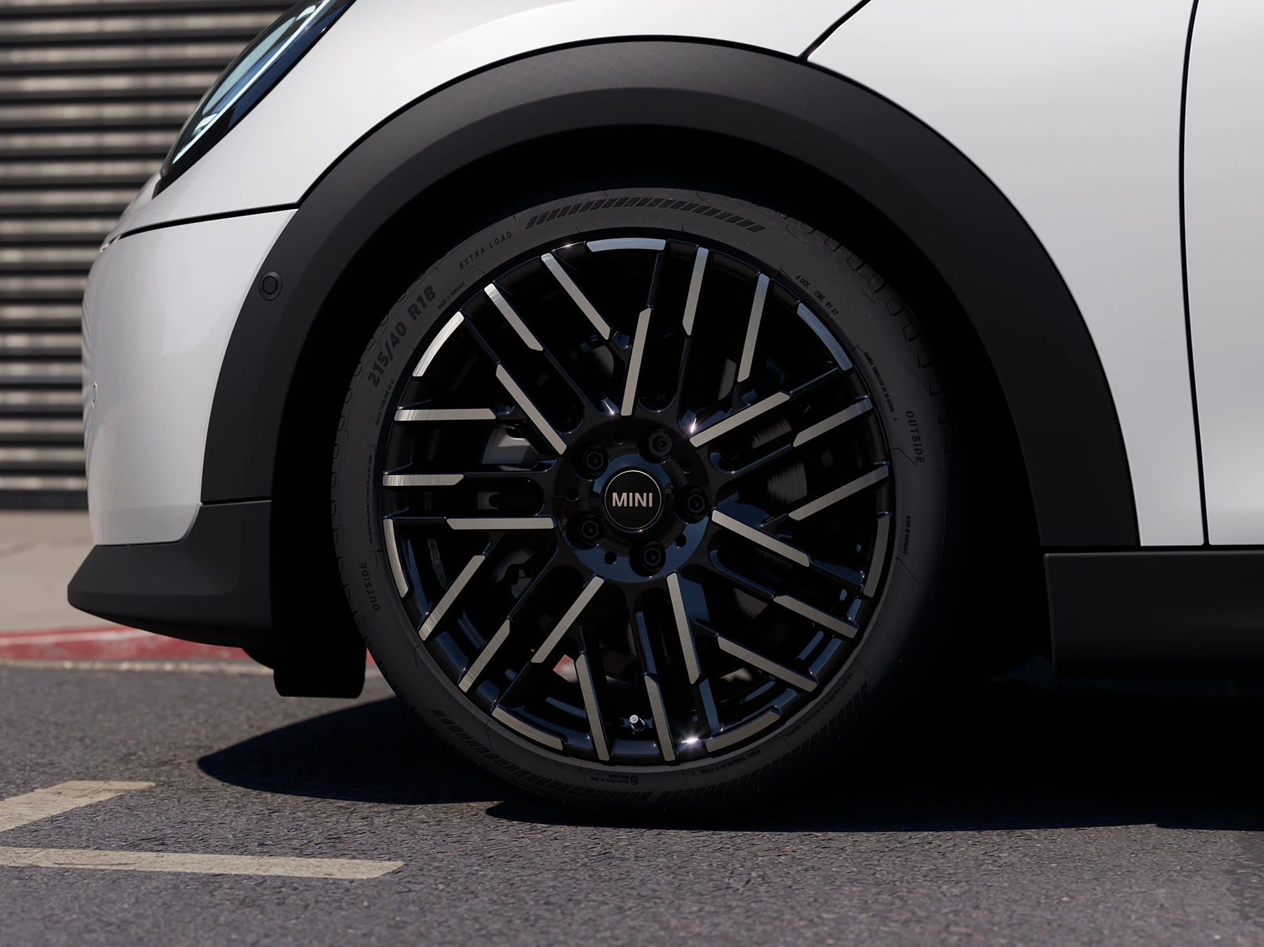 Grande plano do MINI Cooper de 5 portas em Nanuq White com jantes Night Flash Spoke de 2 tons.