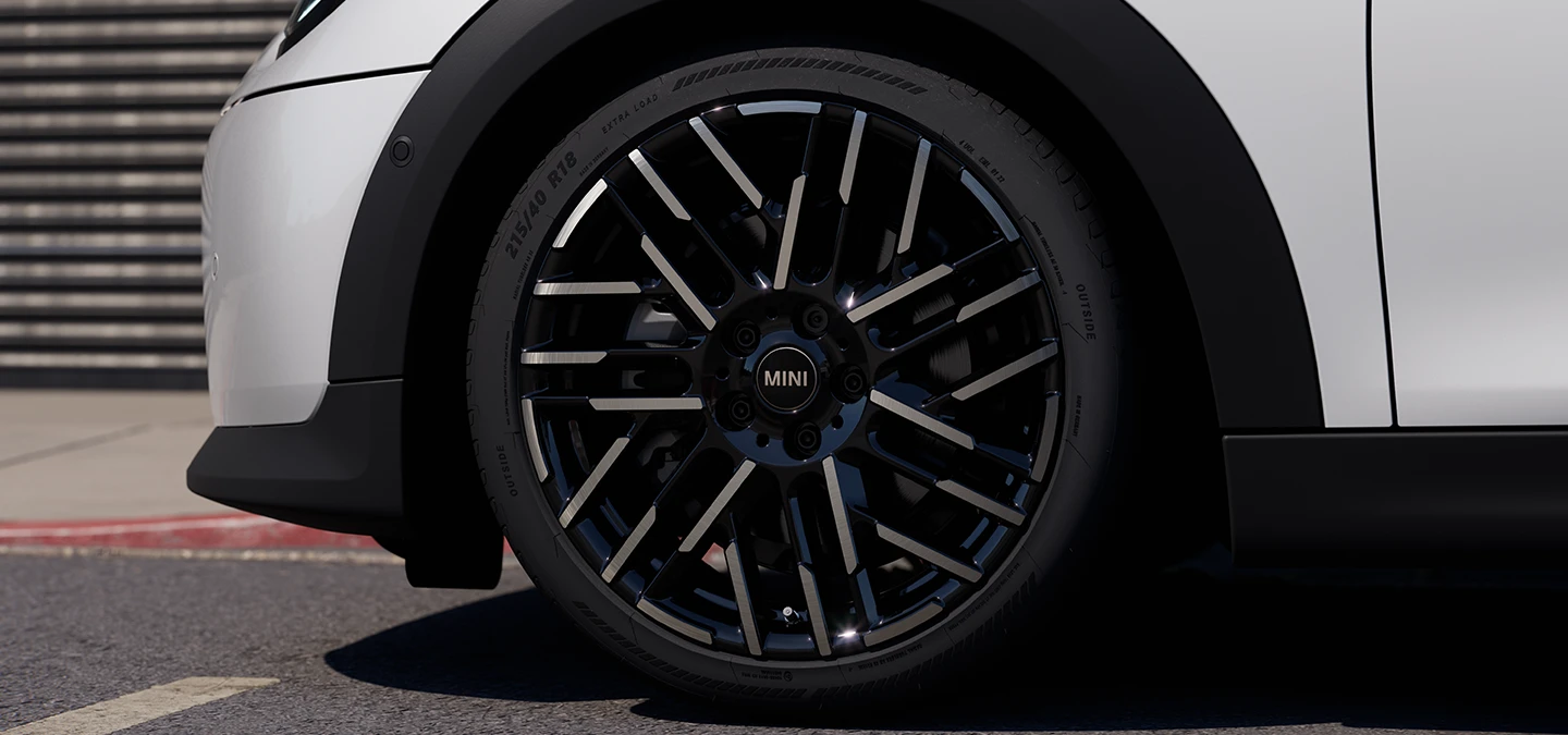 Grande plano do MINI Cooper de 5 portas em Nanuq White com jantes Night Flash Spoke de 2 tons.