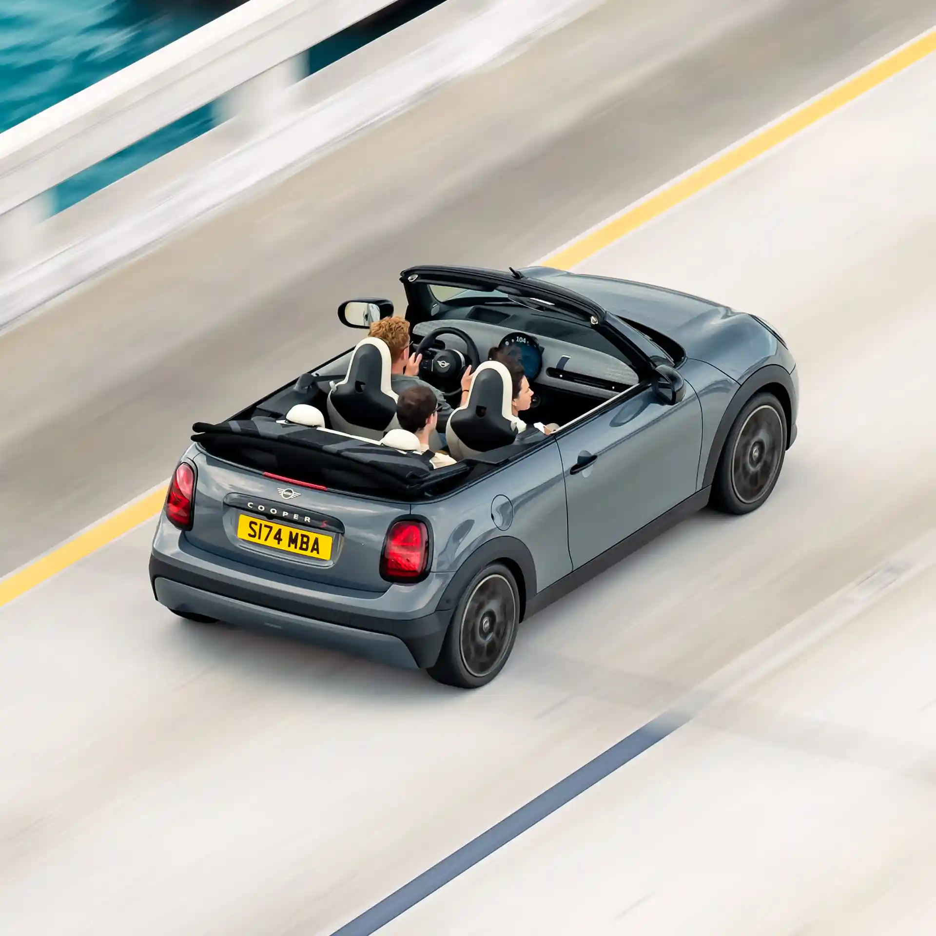 Vista de cima traseira de um MINI Cooper Cabrio em andamento numa rua