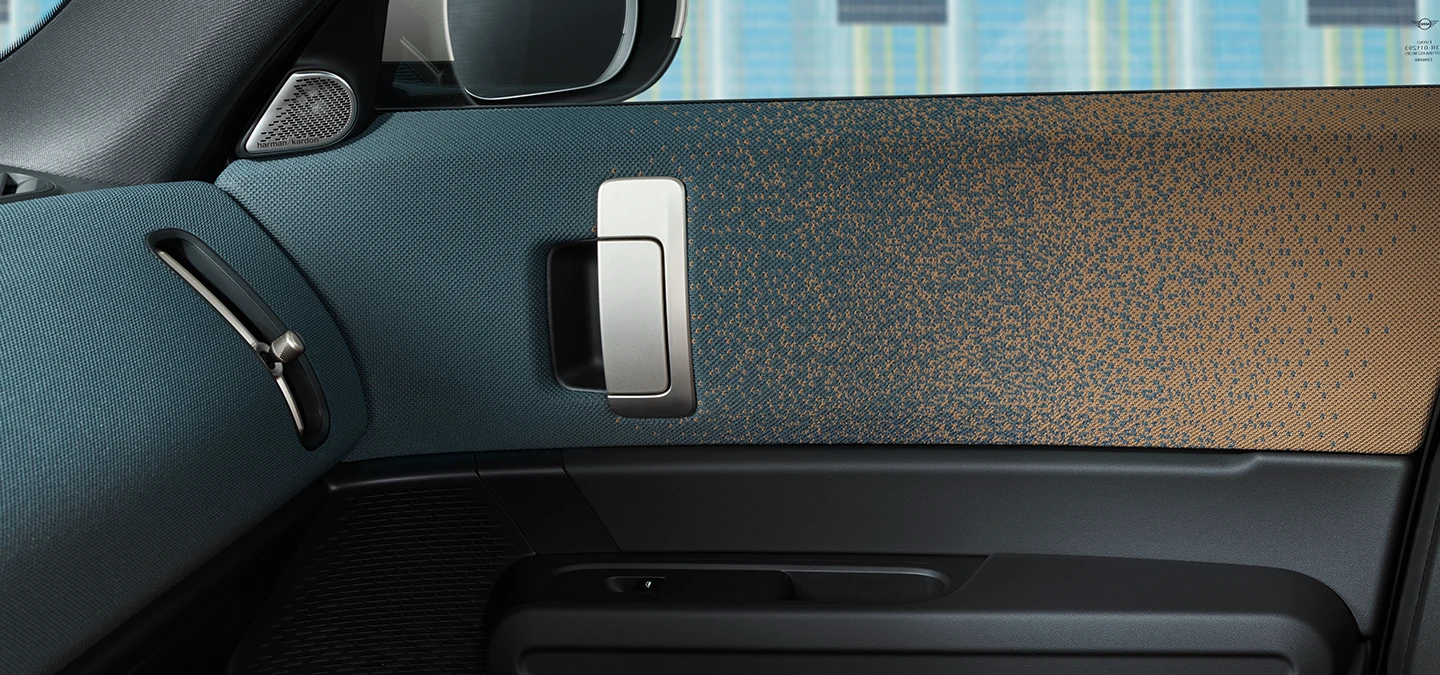Grande plano do design interior do MINI Countryman elétrico com foco na porta e no cockpit.