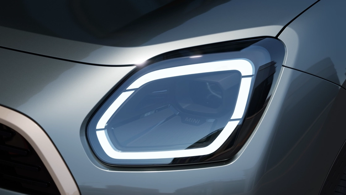 Vista detalhada do farol dianteiro MINI Countryman com a luz branca acesa