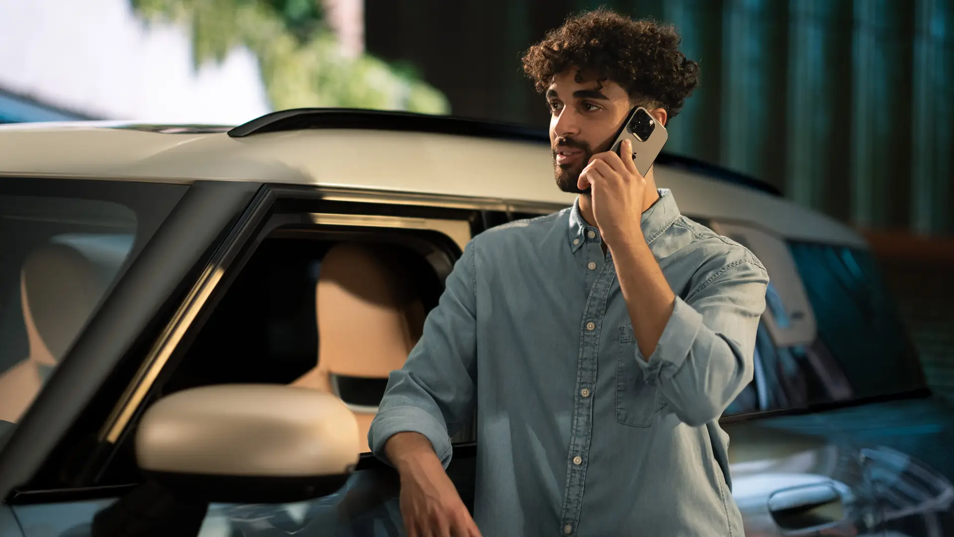 MINI Proactive Care – um homem ao lado do seu MINI, a falar ao telefone com o consultor do Centro de Assistência.