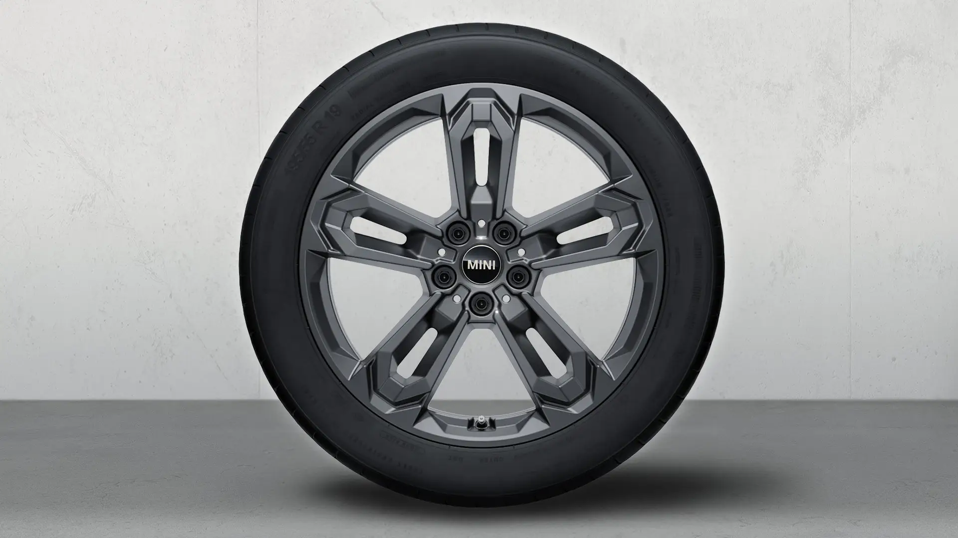 Roda com pneu de inverno e jante de liga leve John Cooper Works 1041 com raios duplos de 19" em Gunmetal Grey. 
