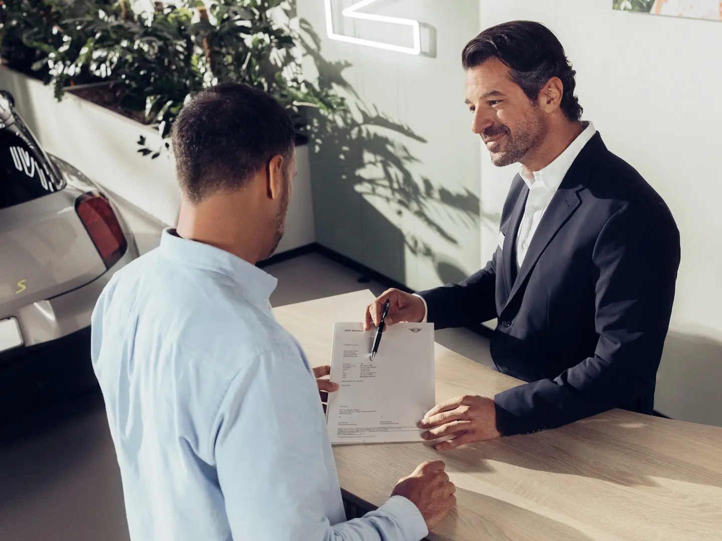 Um assistente de serviço do parceiro MINI aconselha um cliente sobre as opções de seguro para pneus MINI.