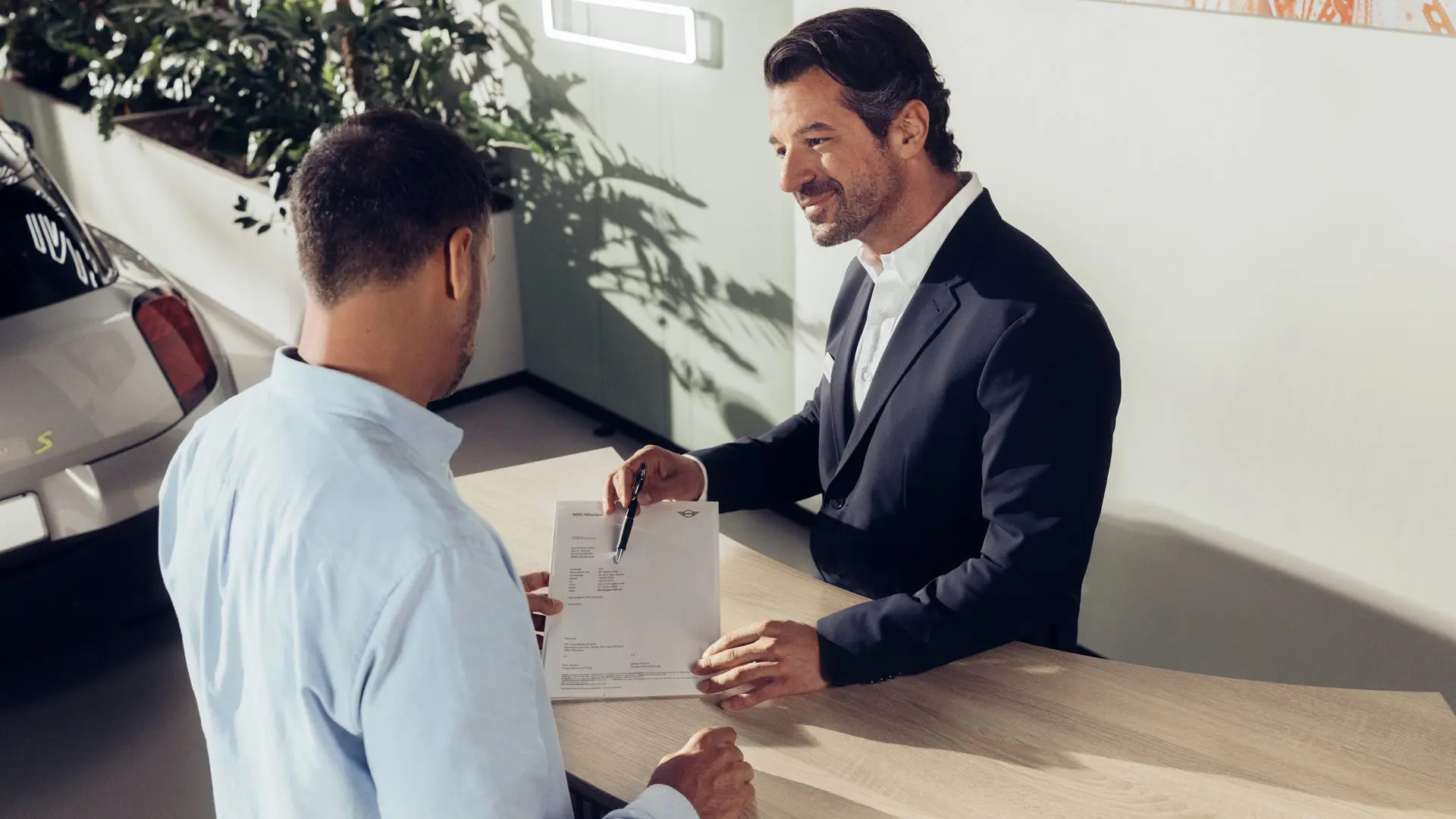 Um assistente de serviço do parceiro MINI aconselha um cliente sobre as opções de seguro para pneus MINI.