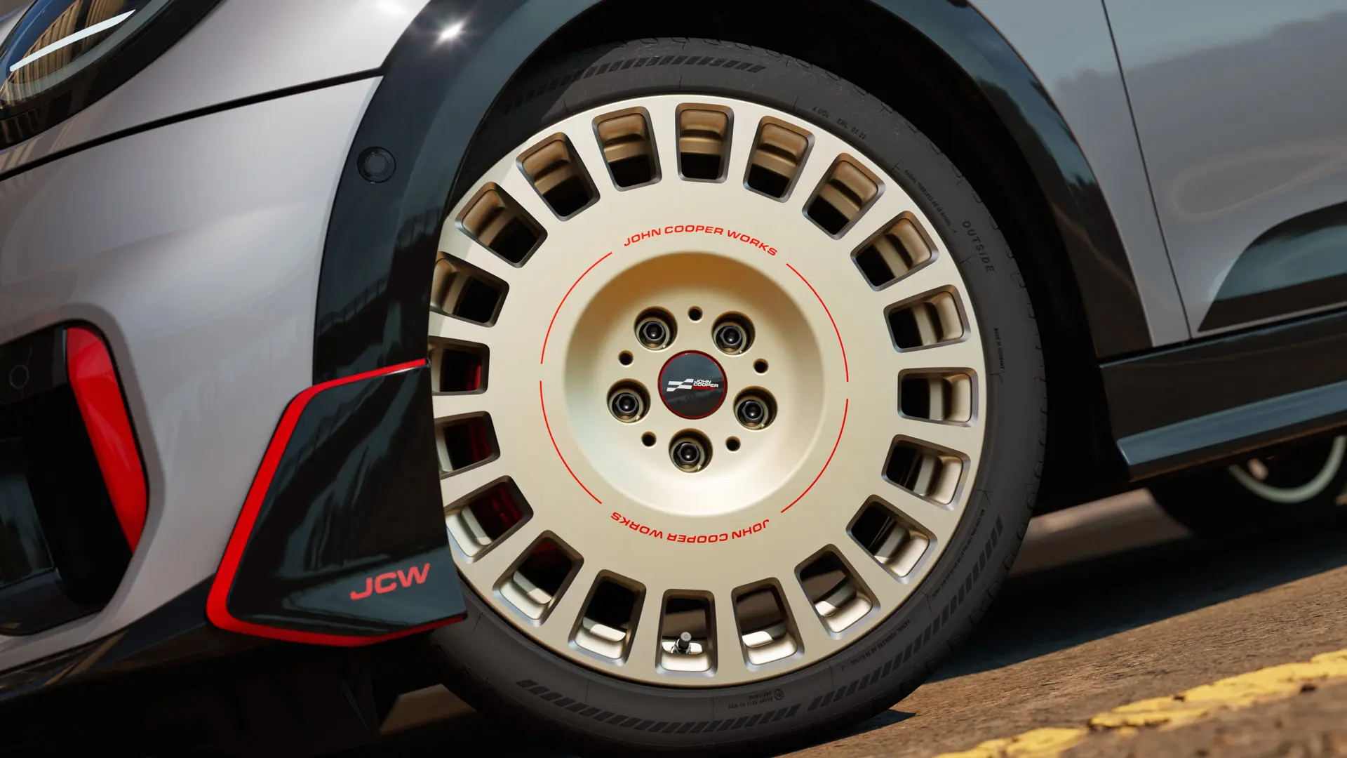 Grande plano dos detalhes de uma roda JCW Rallye Spoke 964 de 18" em Bicolour Vibrant Silver e com winglet dianteiro e fresado brilhante.