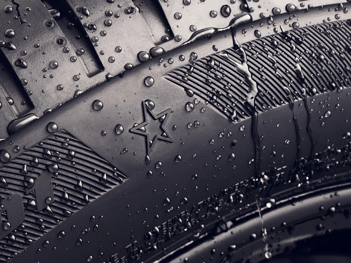 Grande plano da parede lateral de um pneu com o símbolo da estrela, que indica que está aprovado para um desempenho ideal em veículos MINI. 