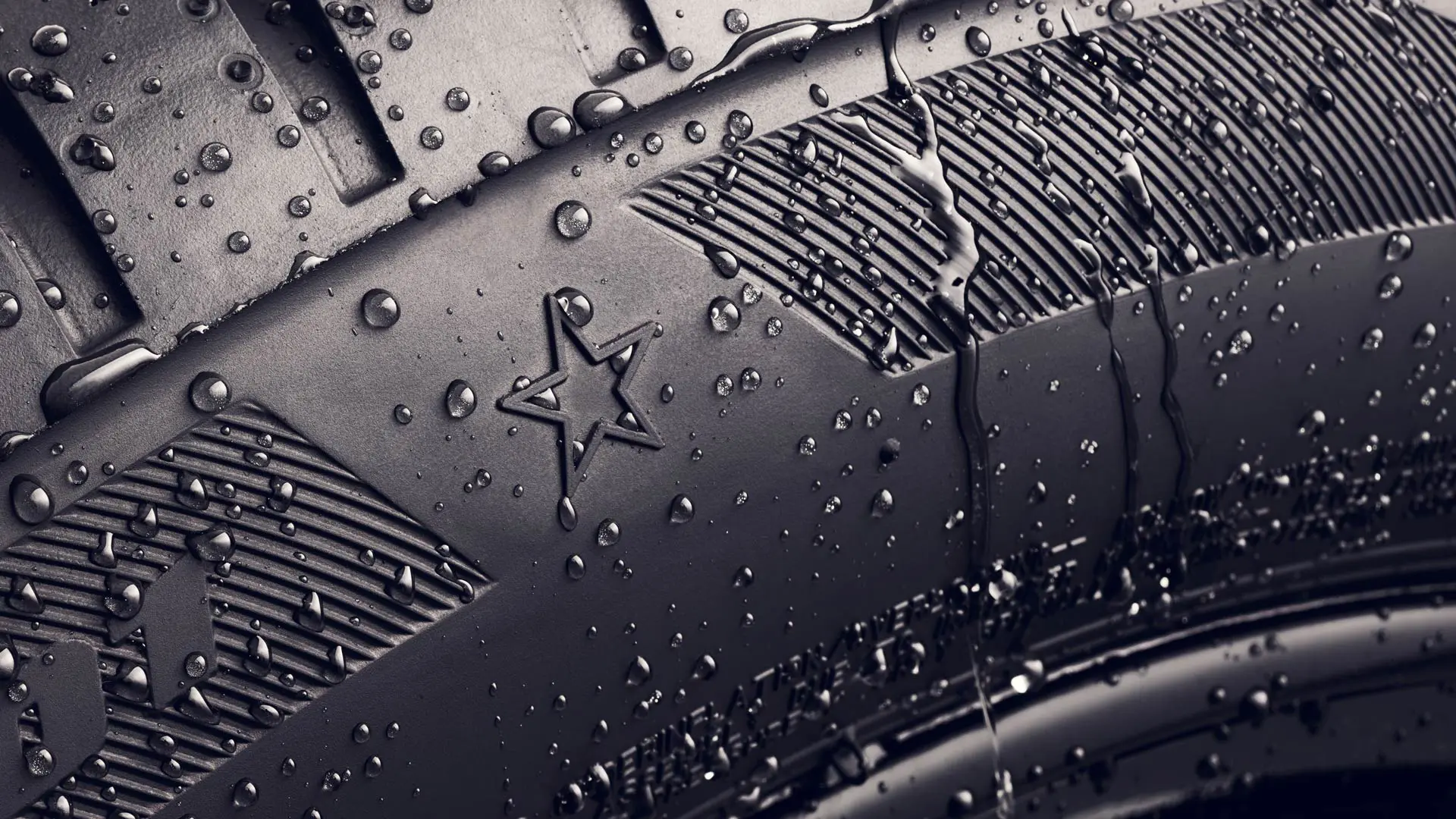 Grande plano da parede lateral de um pneu com o símbolo da estrela, que indica que está aprovado para um desempenho ideal em veículos MINI. 