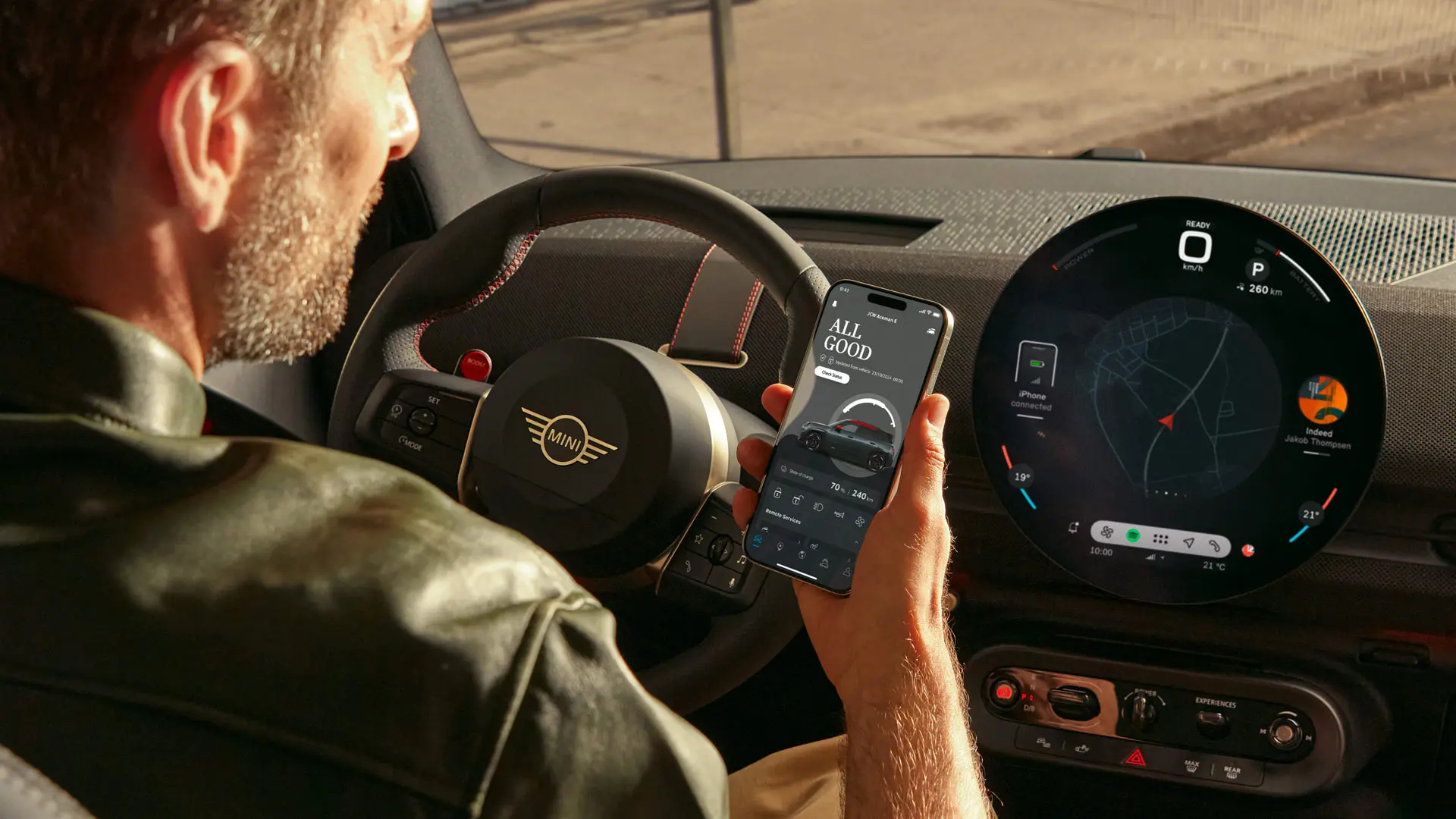 Condutor MINI utilizando a aplicação MINI no seu telemóvel para serviços de navegação.