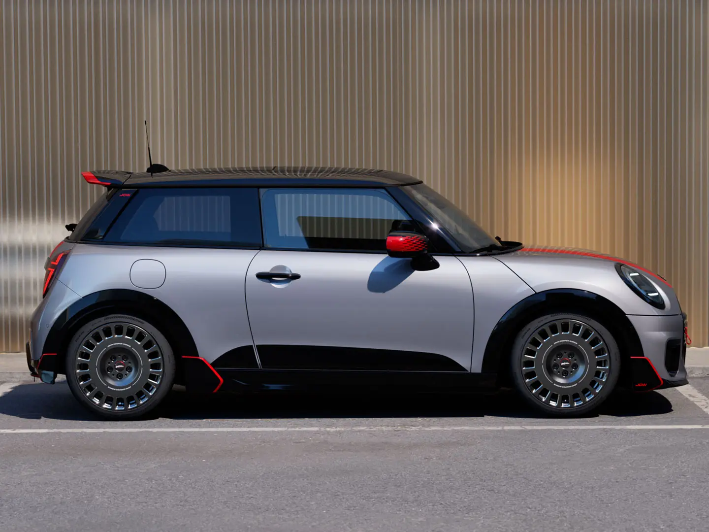 MINI Cooper de 3 portas em Melting Silver com spoiler de tejadilho John Cooper Works para melhores propriedades aerodinâmicas – vista lateral.