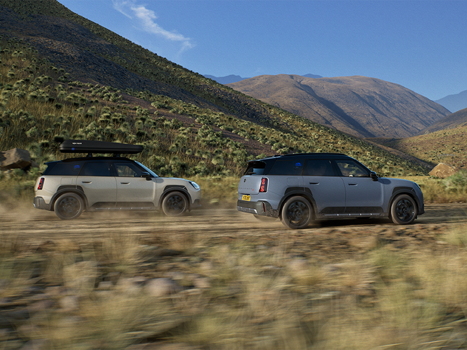 Imagem de dois veículos MINI Countryman Untamed Edition a circular, vistos de trás.