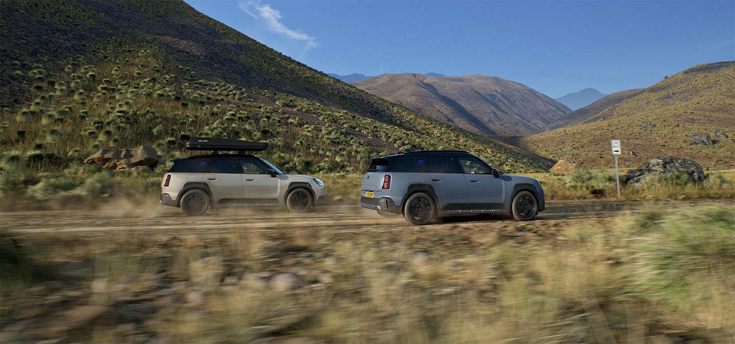Imagem de dois veículos MINI Countryman Untamed Edition a circular, vistos de trás.