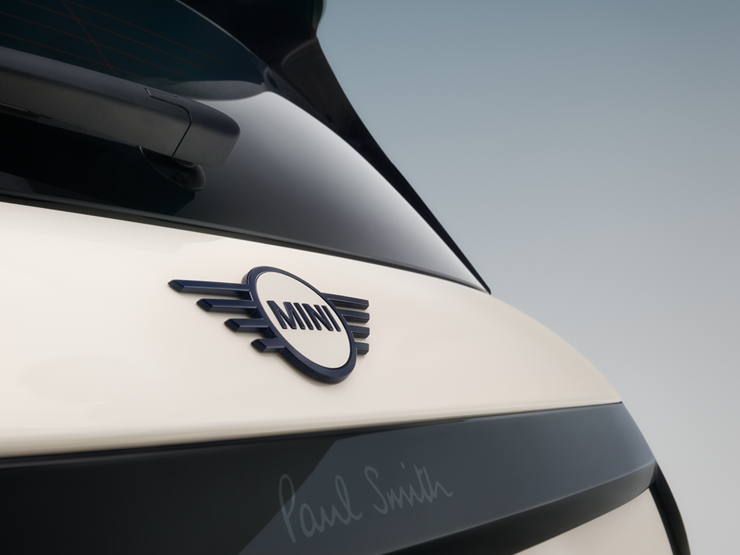 Imagem em grande plano do emblema traseiro em forma de asa do MINI Cooper Paul Smith Edition elétrico, em Inspired White