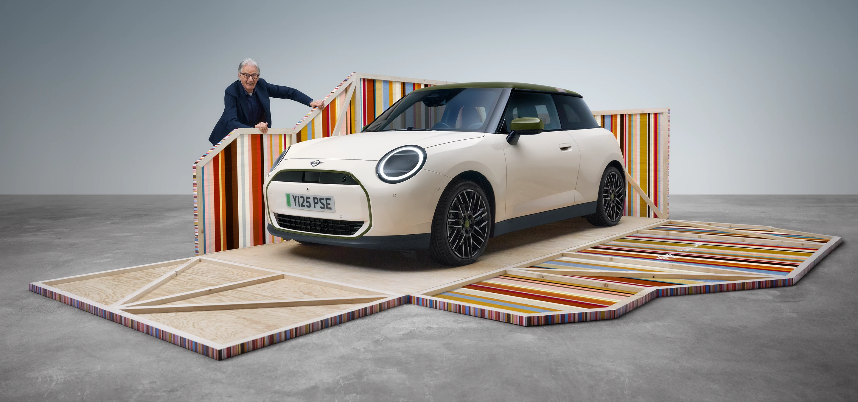 Vista frontal do MINI Cooper elétrico Paul Smith Edition em Inspired White com o designer Paul Smith