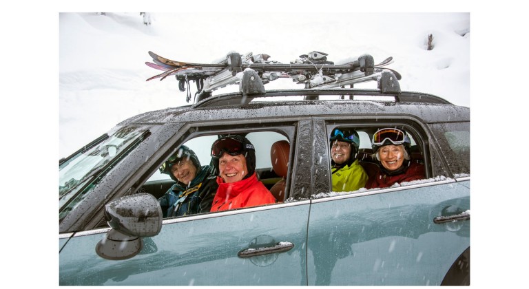 Imagem do MINI John Cooper Works Countryman ALL4, numa paisagem de neve com a equipa de esqui “Silver Sliders” a sorrir pela janela do carro.