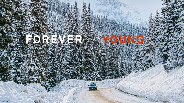 Imagem com o texto "Forever Young" e podemos ver o MINI John Cooper Works Countryman ALL4 numa estrada com neve, em Whitewater na Colúmbia Britânica, Canadá.