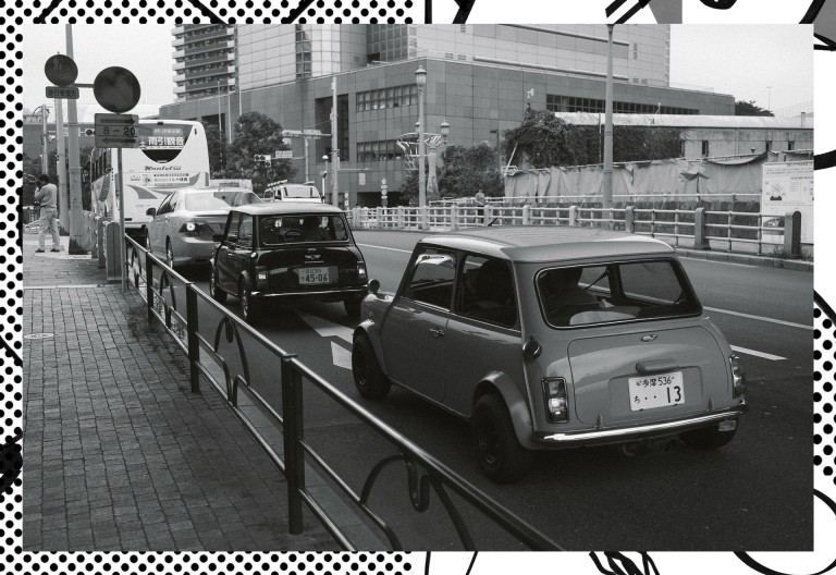 Imagem a preto e branco que mostra vários Minis clássico nas ruas do Japão.