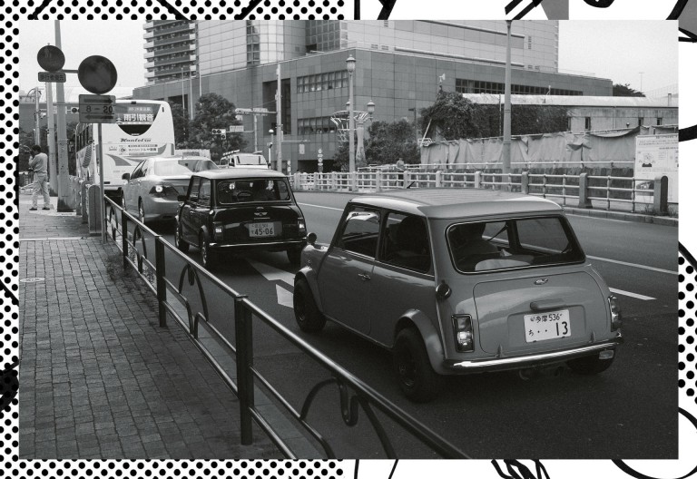 Imagem a preto e branco que mostra vários Minis clássico nas ruas do Japão.