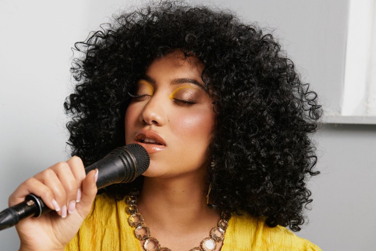 Sophia Thakur a cantar com um microfone na mão.
