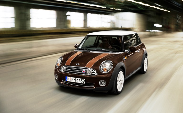 Desportivo MINI 50 Mayfair, de 2009, na cor castanho, com teto branco, frisos cromados, cavas das rodas de antracite e emblemas especiais.
