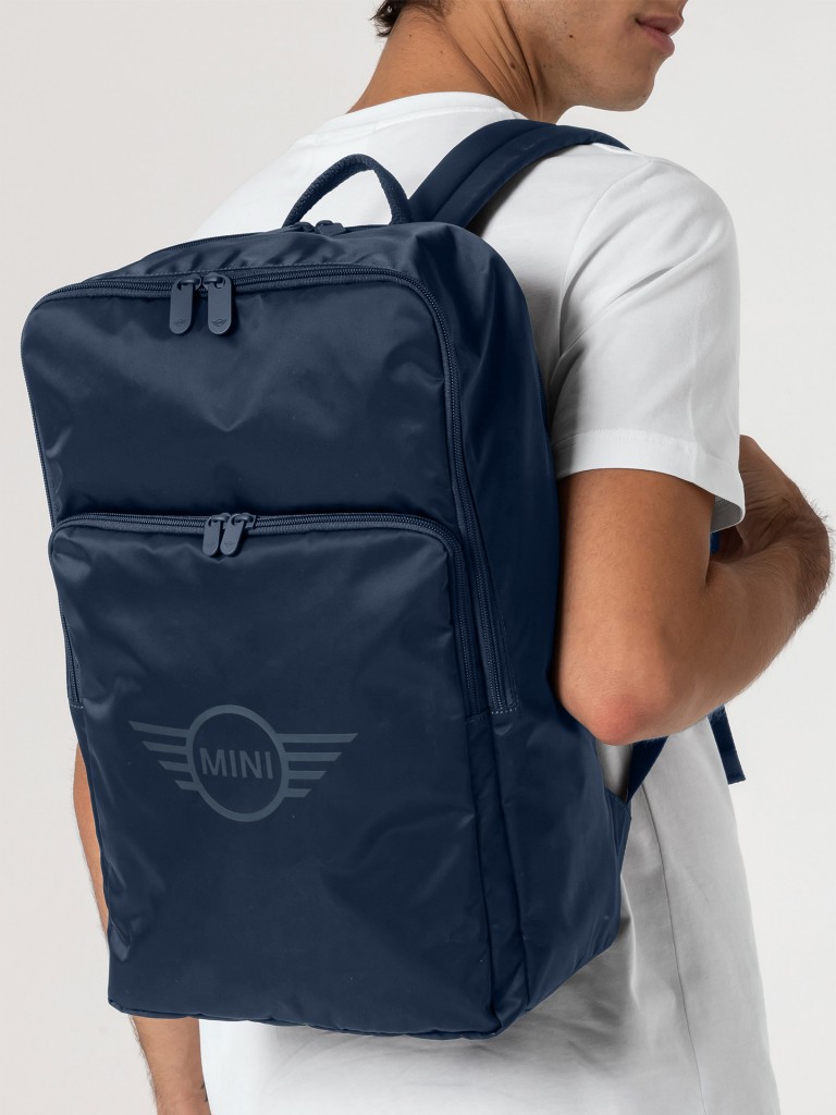 Mochila MINI azul profundo com alça de transporte, bolsos com zíper e logotipo.