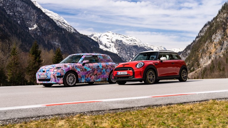 O novo MINI Cooper Electric da nova família MINI e o atual MINI Cooper SE lado a lado na estrada.