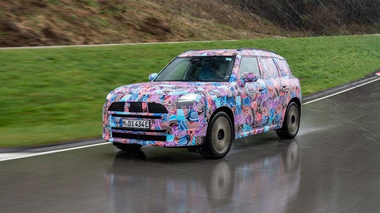 Vista frontal do novo MINI Countryman camuflado na estrada.