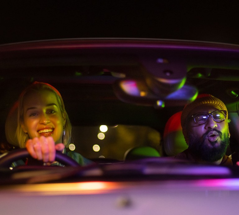 Mulher a conduzir um MINI e homem ao lado a cantar - MINI Big Love.